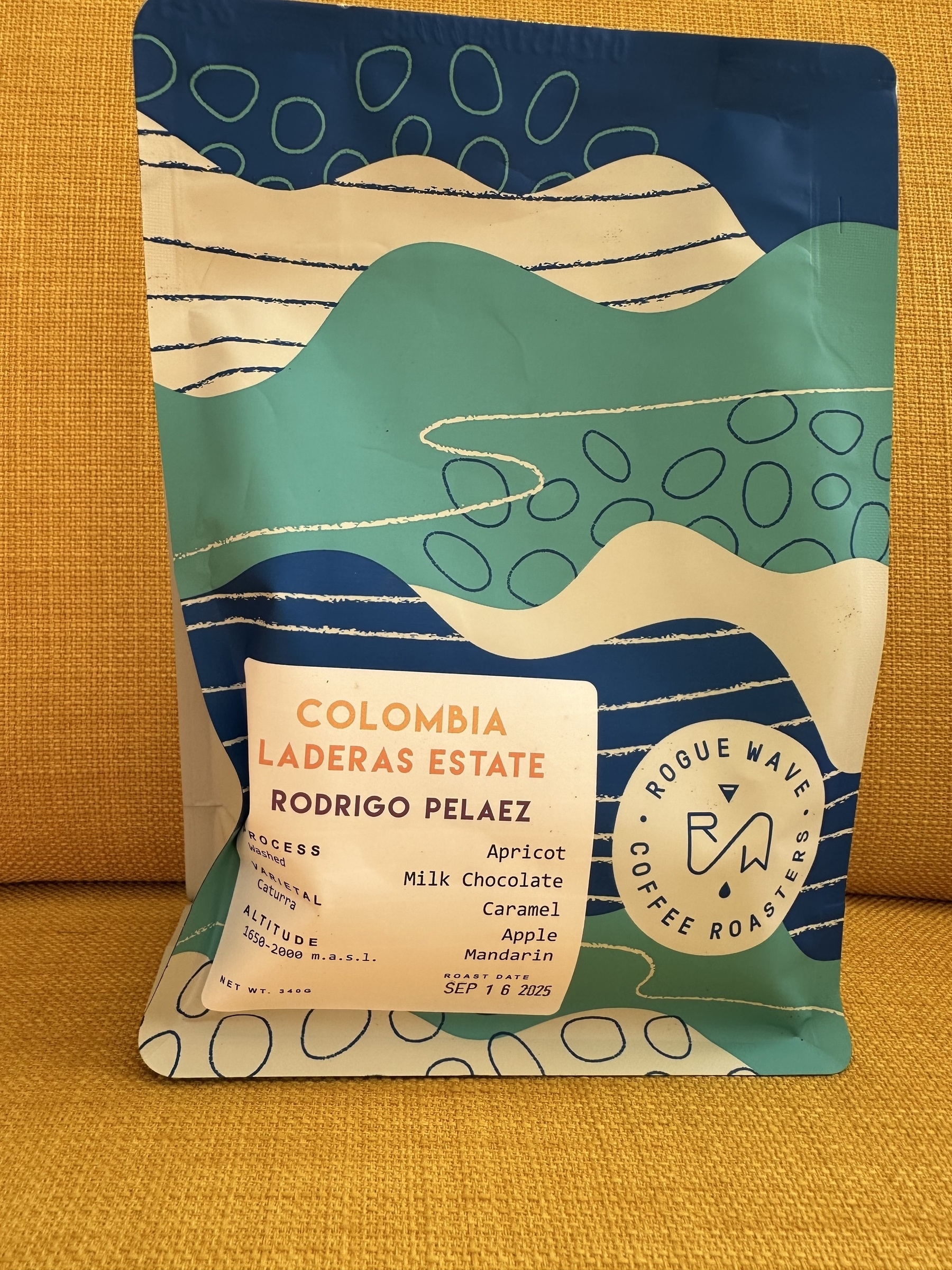 A colorful coffee bag featuring a design of abstract waves and a label detailing the coffee's origin, flavor notes, and roaster information.