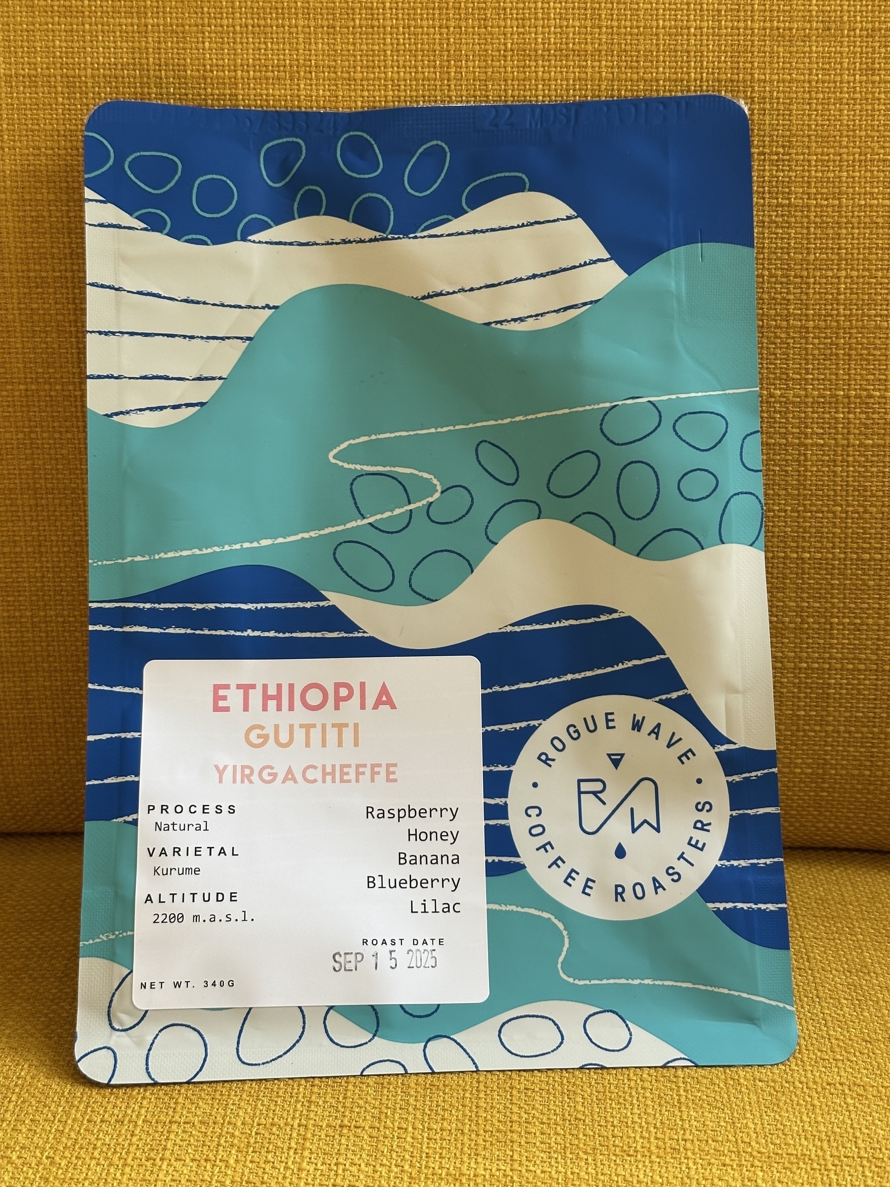 A colorful coffee package features information about Ethiopian Yirgacheffe coffee with flavor notes of raspberry, honey, banana, blueberry, and lilac.