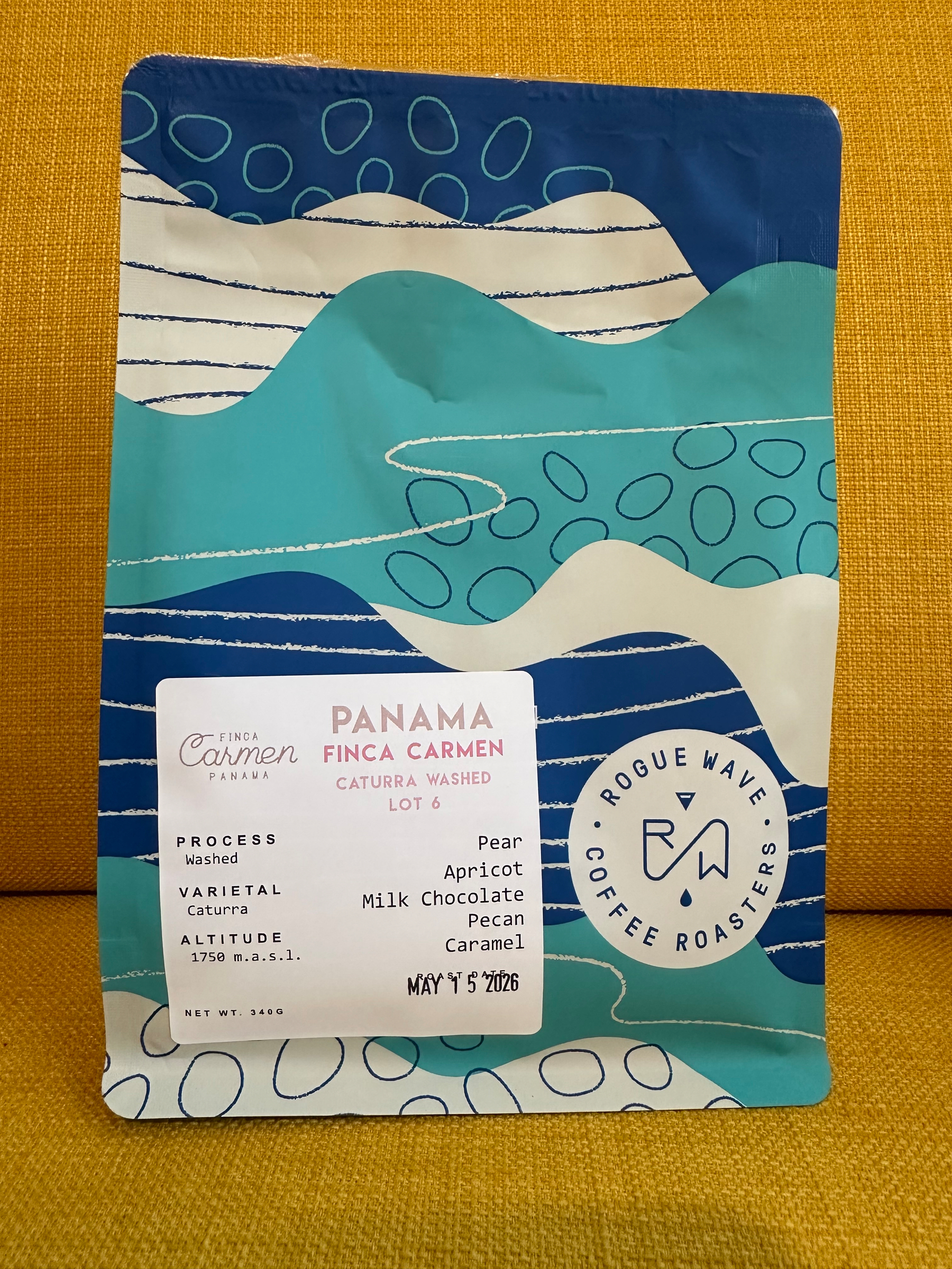 A colorful coffee package with abstract art and information about a Panama coffee blend featuring flavor notes of pear, apricot, milk chocolate, and pecan.