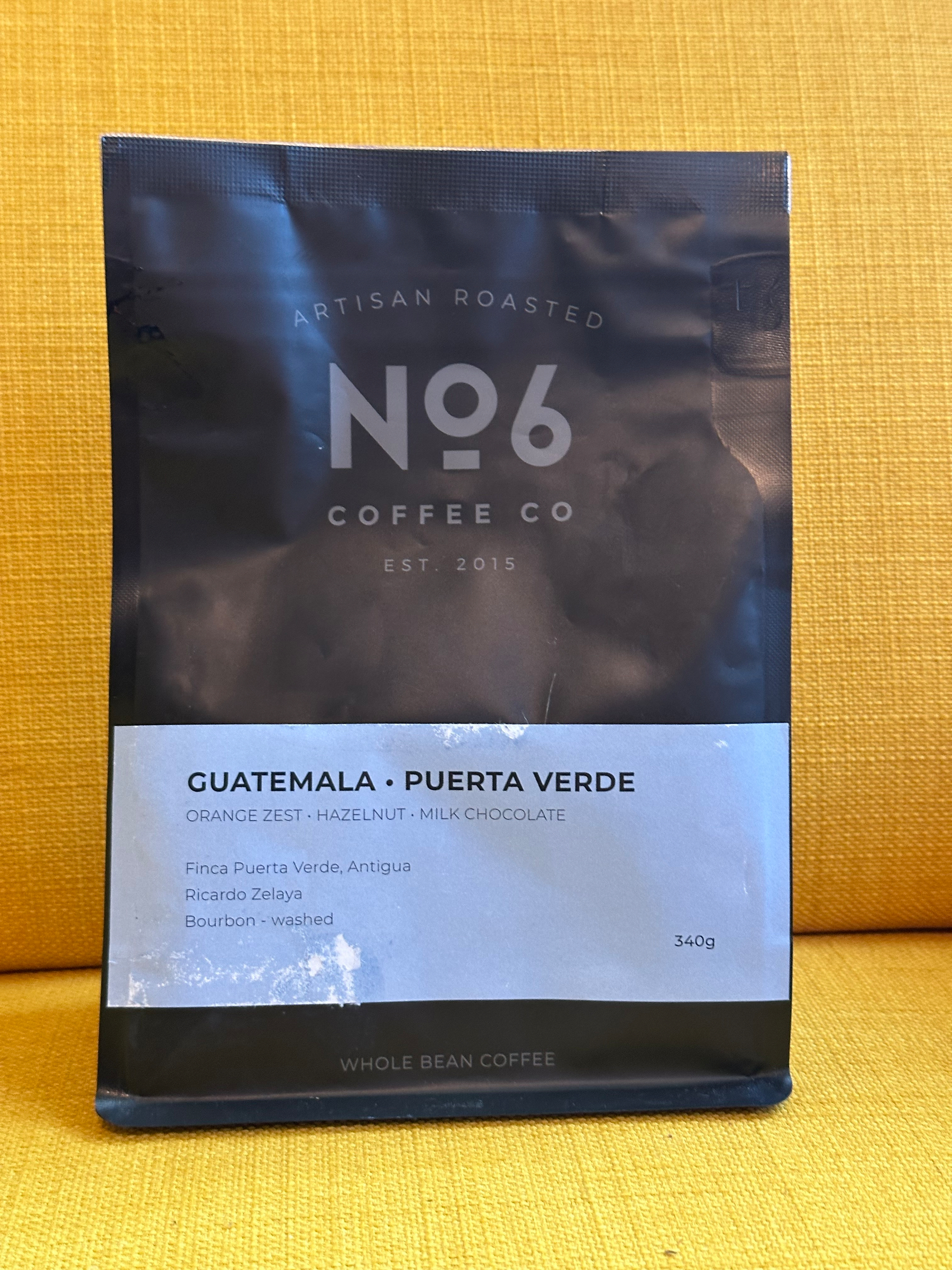 A bag of No. 6 Coffee Co artisan roasted whole bean coffee from Guatemala, Puerta Verde, featuring tasting notes of orange zest, hazelnut, and milk chocolate.