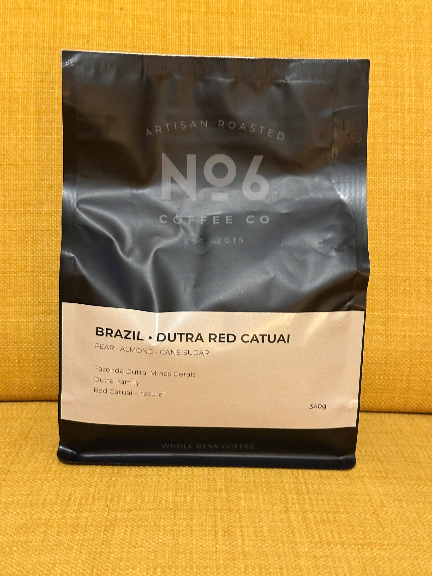 A black and beige bag of No6 Coffee Co artisan roasted whole bean coffee labeled Brazil Dutra Red Catuai with tasting notes of pear, almond, and cane sugar.